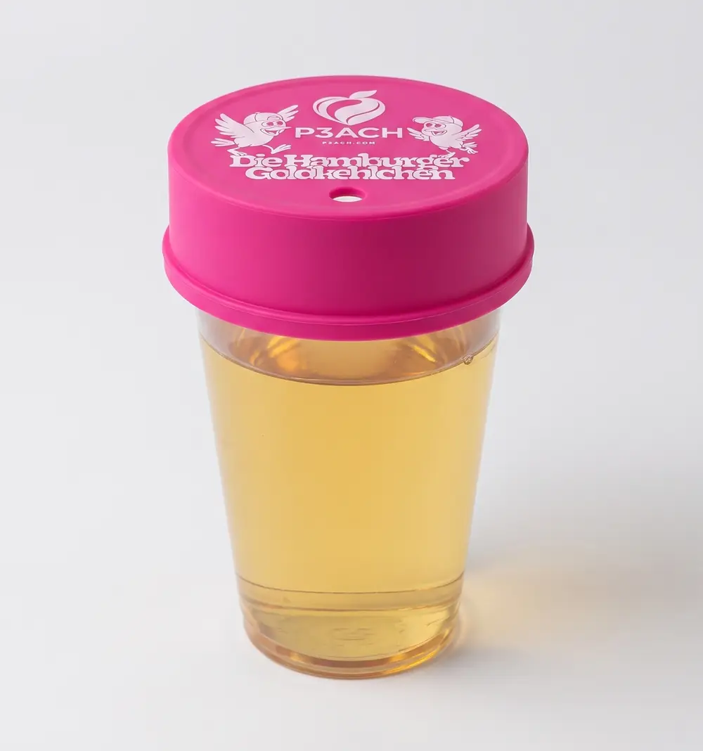 Der P3ACH Cup Cover der Goldkehlchen-Edition auf einem Stadionbecher